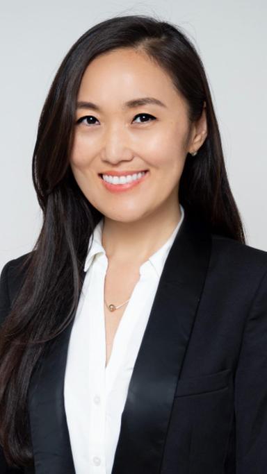 A portrait of a woman smiling directly at the camera.