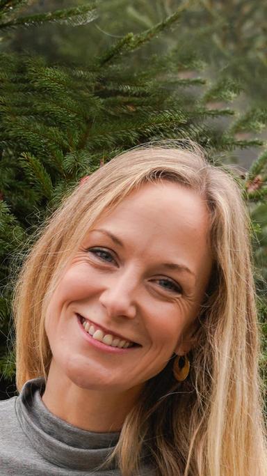 A woman with blonde hair smiling at the camera.