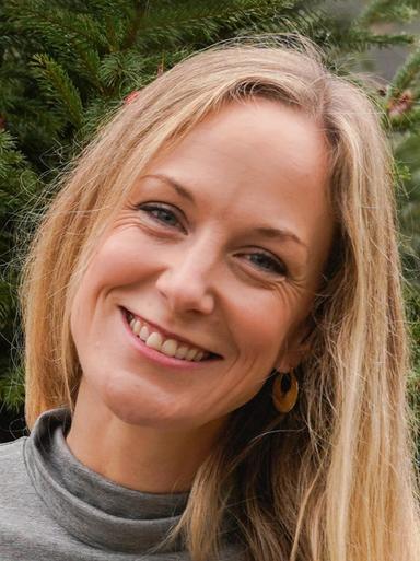 A woman with blonde hair smiling at the camera.