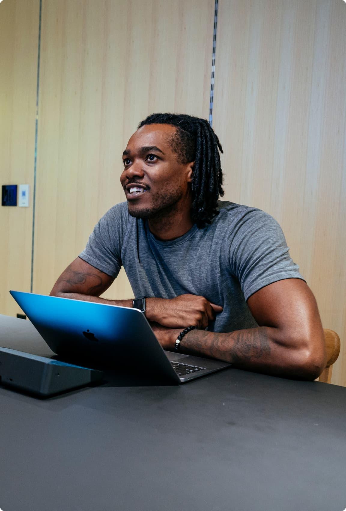 Man looking up from his laptop smiling
