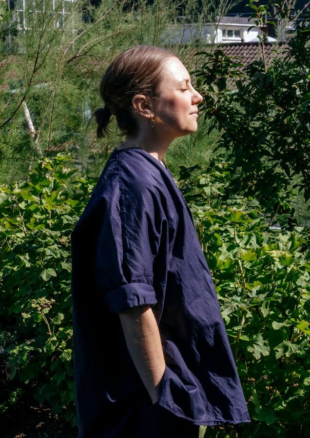 woman wearing black smiling towards the sun outside