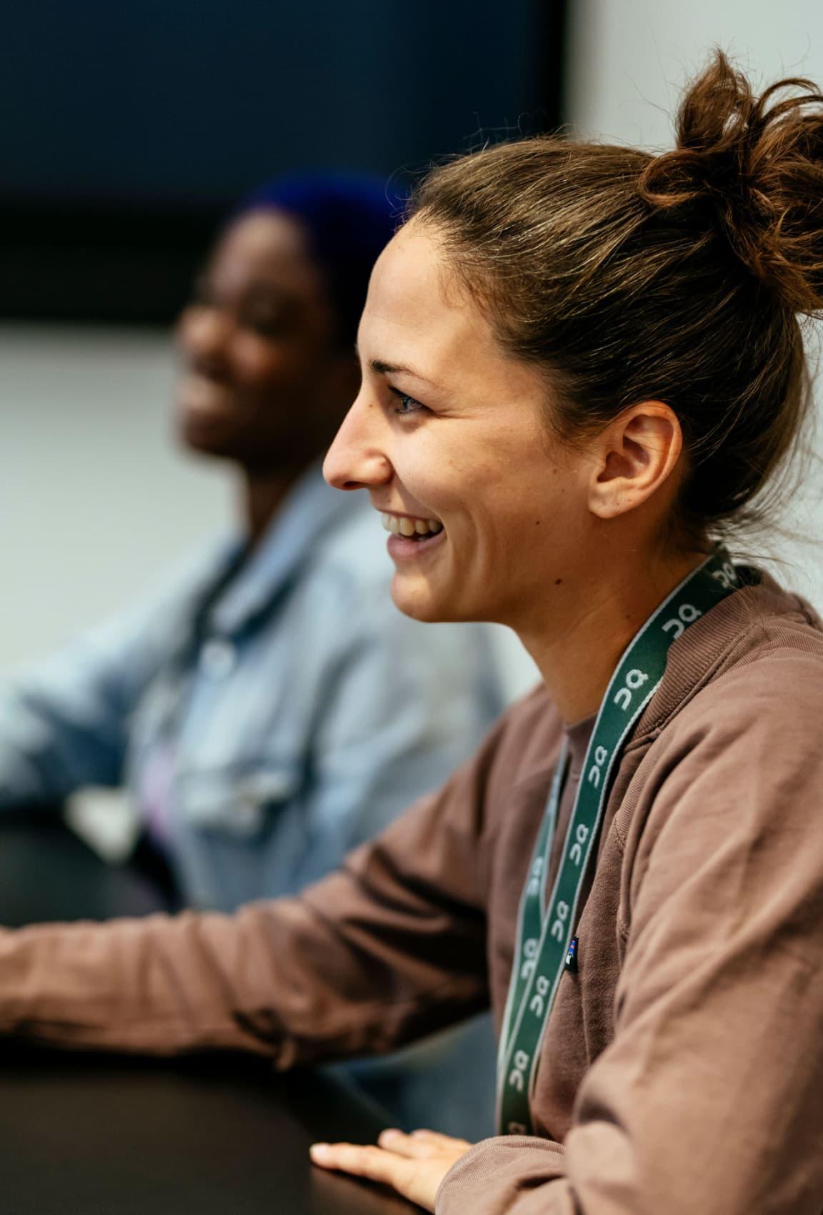 A woman smiling whilst sitting at a desk.