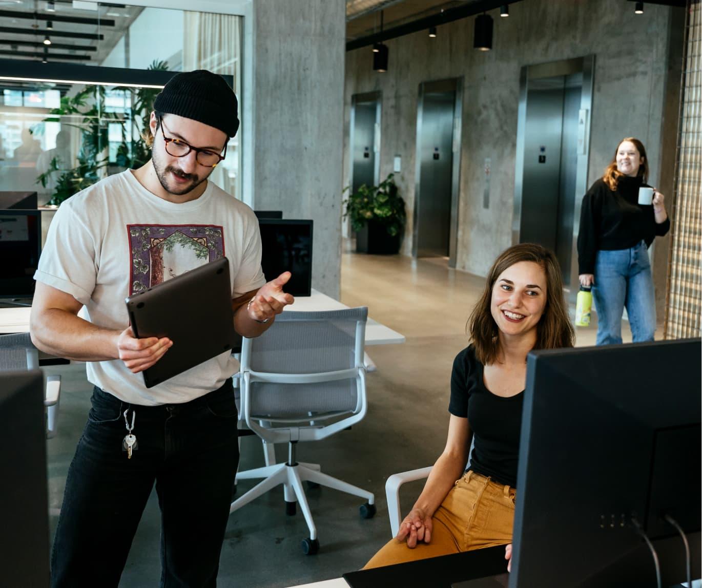 A man and woman talking to each other at a desk.