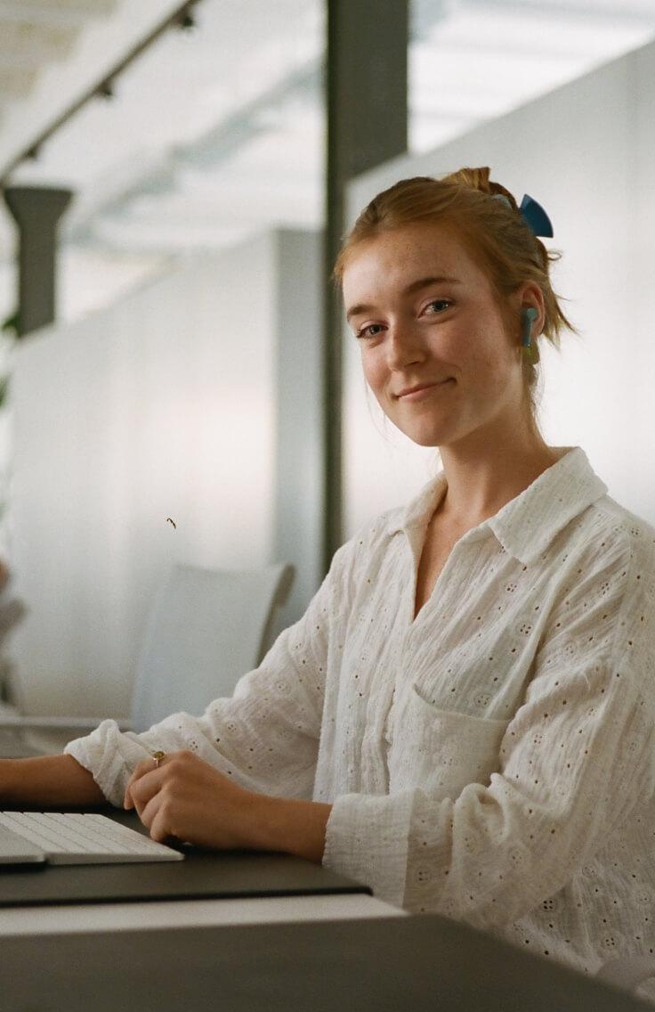woman in white shirt smiling at camera