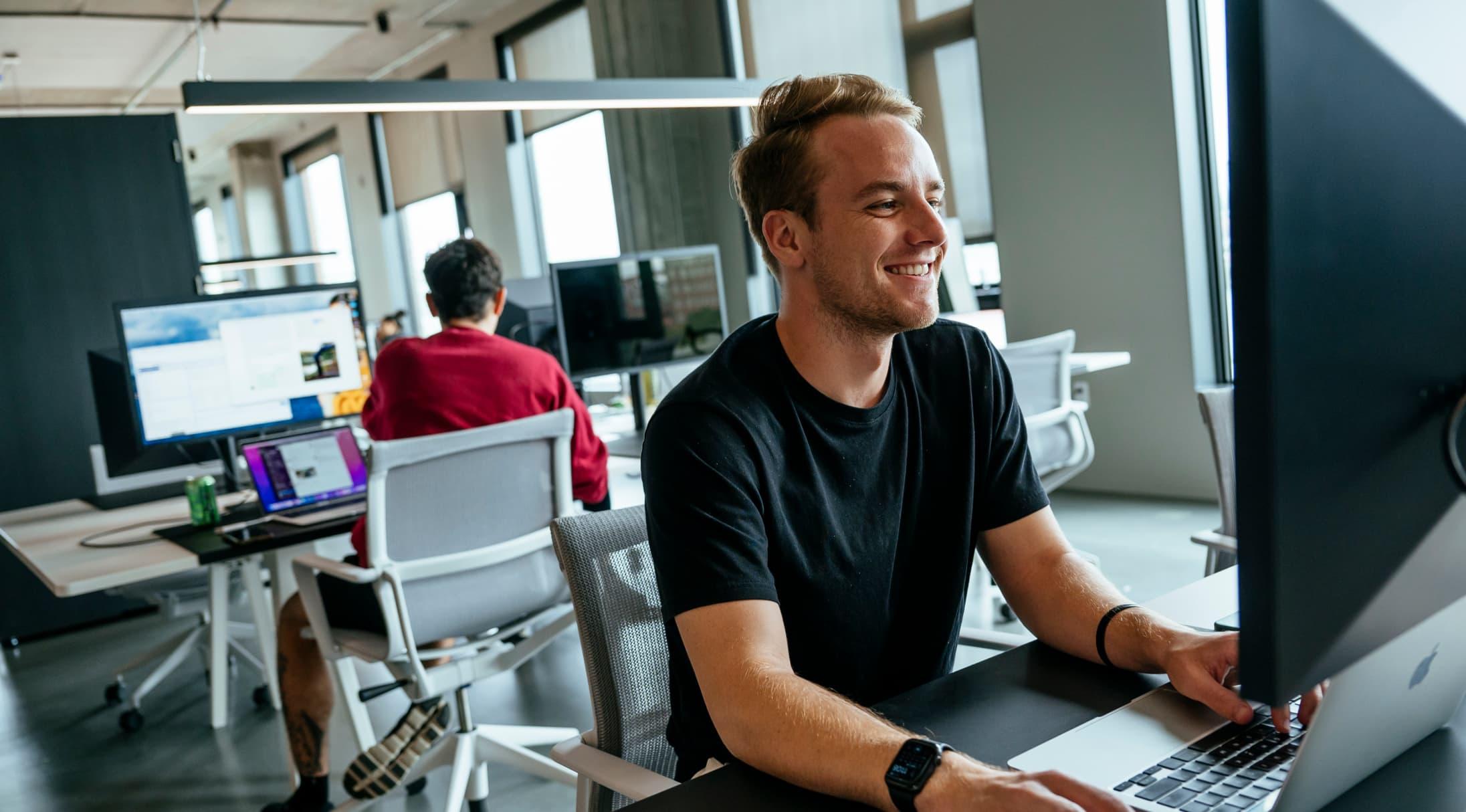 Man smiling at desktop computer