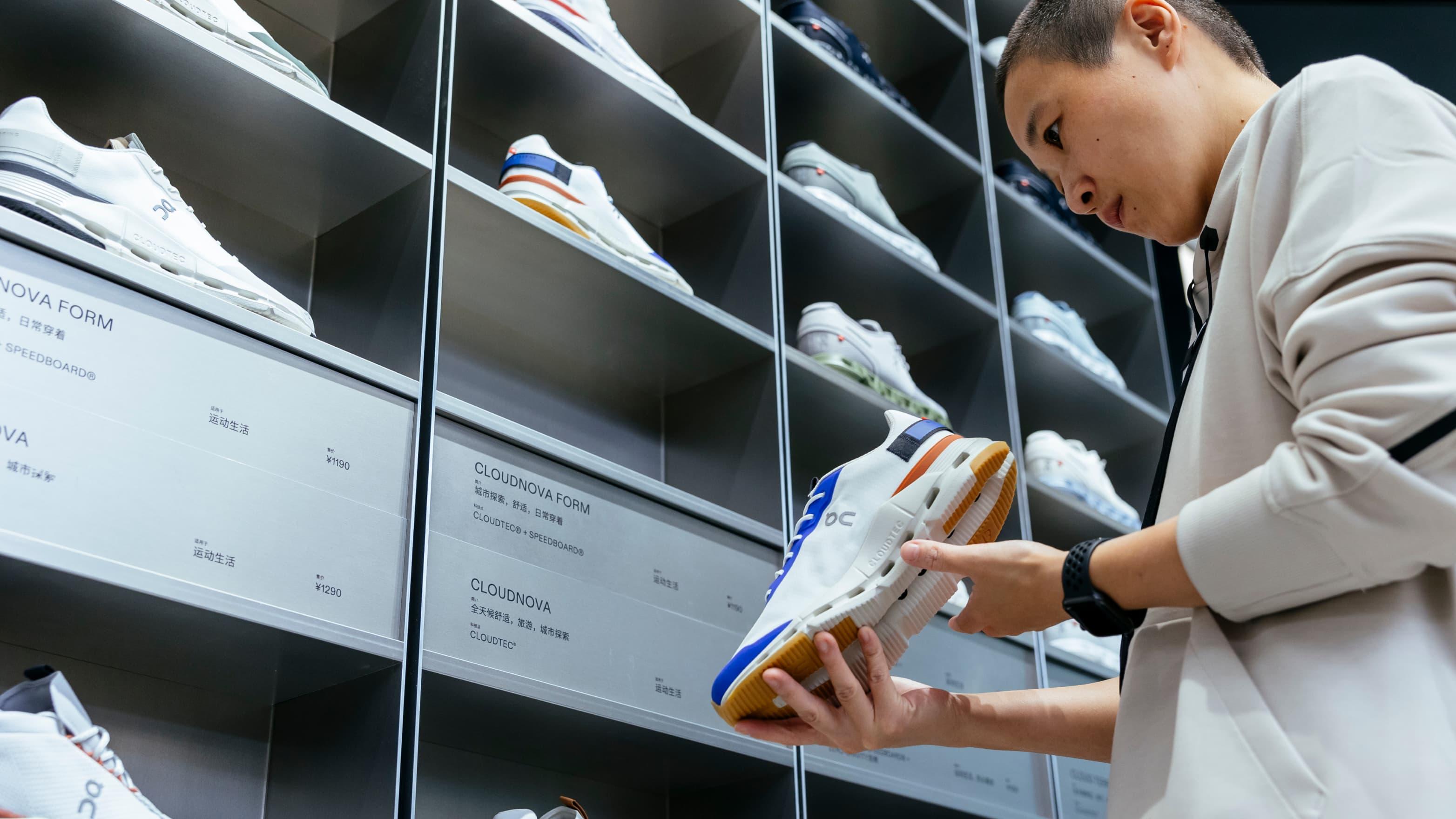 Woman checks shoes quality near the shoe stand