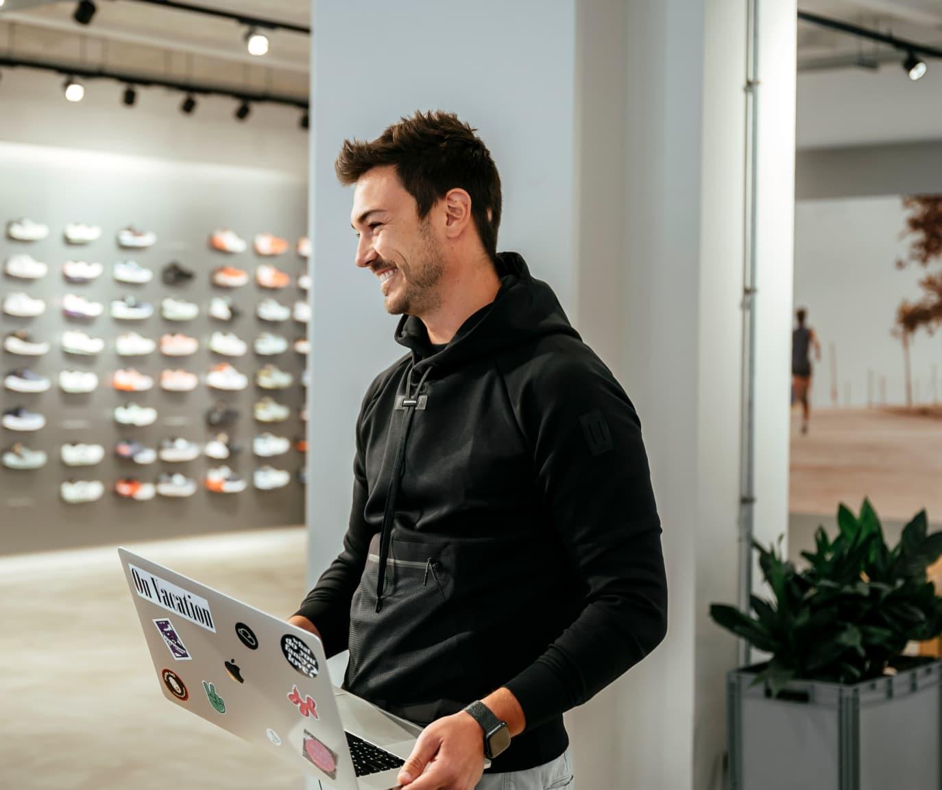 Man smiling with laptop in hands.