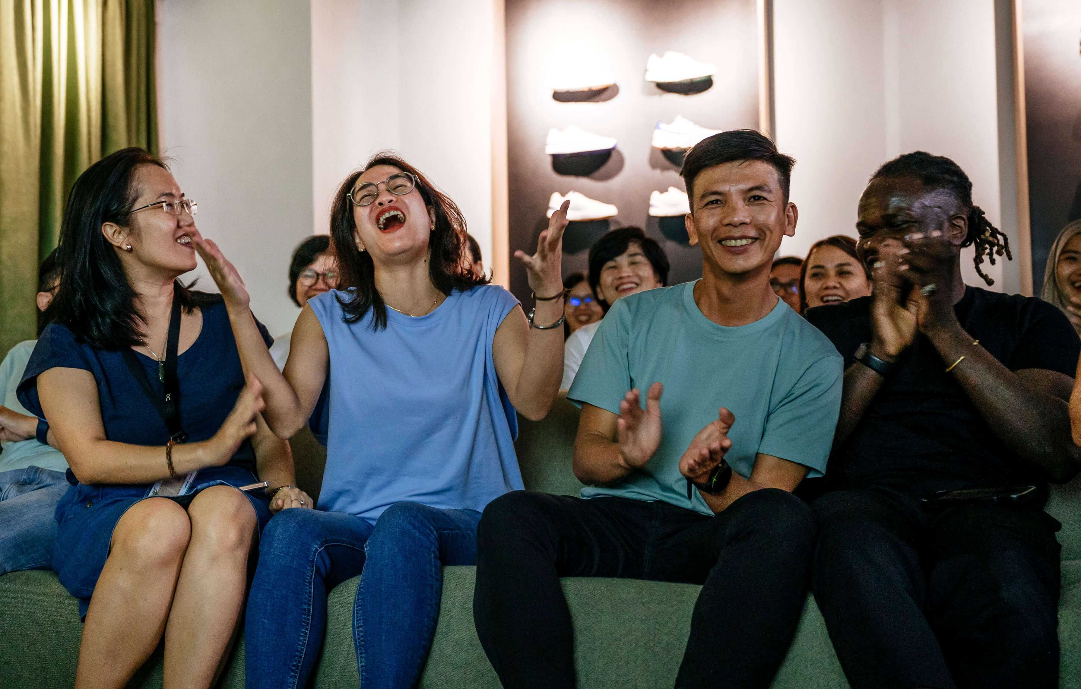 group of employees sitting clapping in sportswear