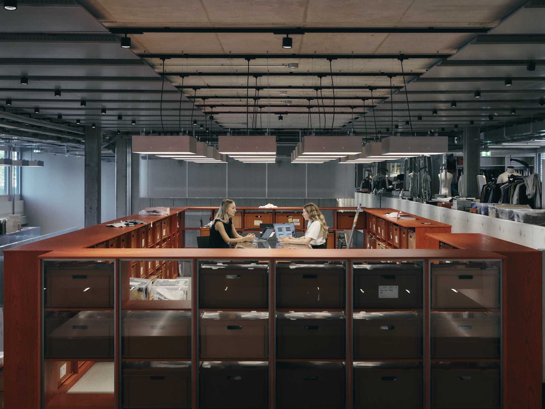 Two women in an open-plan office sat at a table face-to-face
