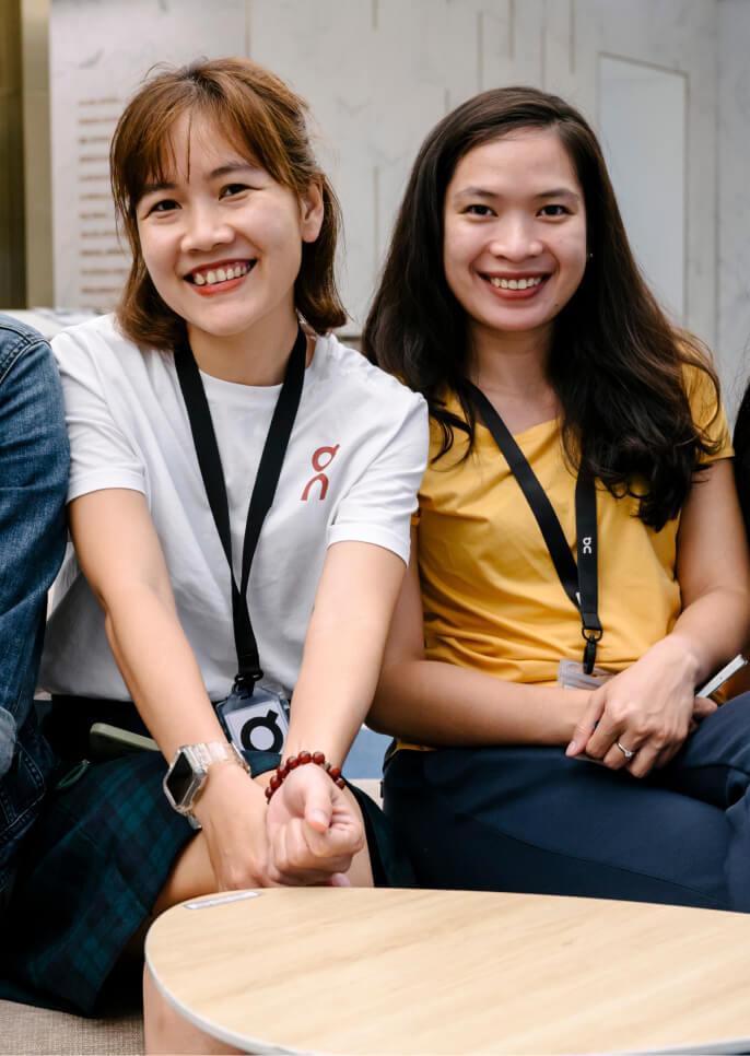 Two brunette woman smiling and looking towards the camera