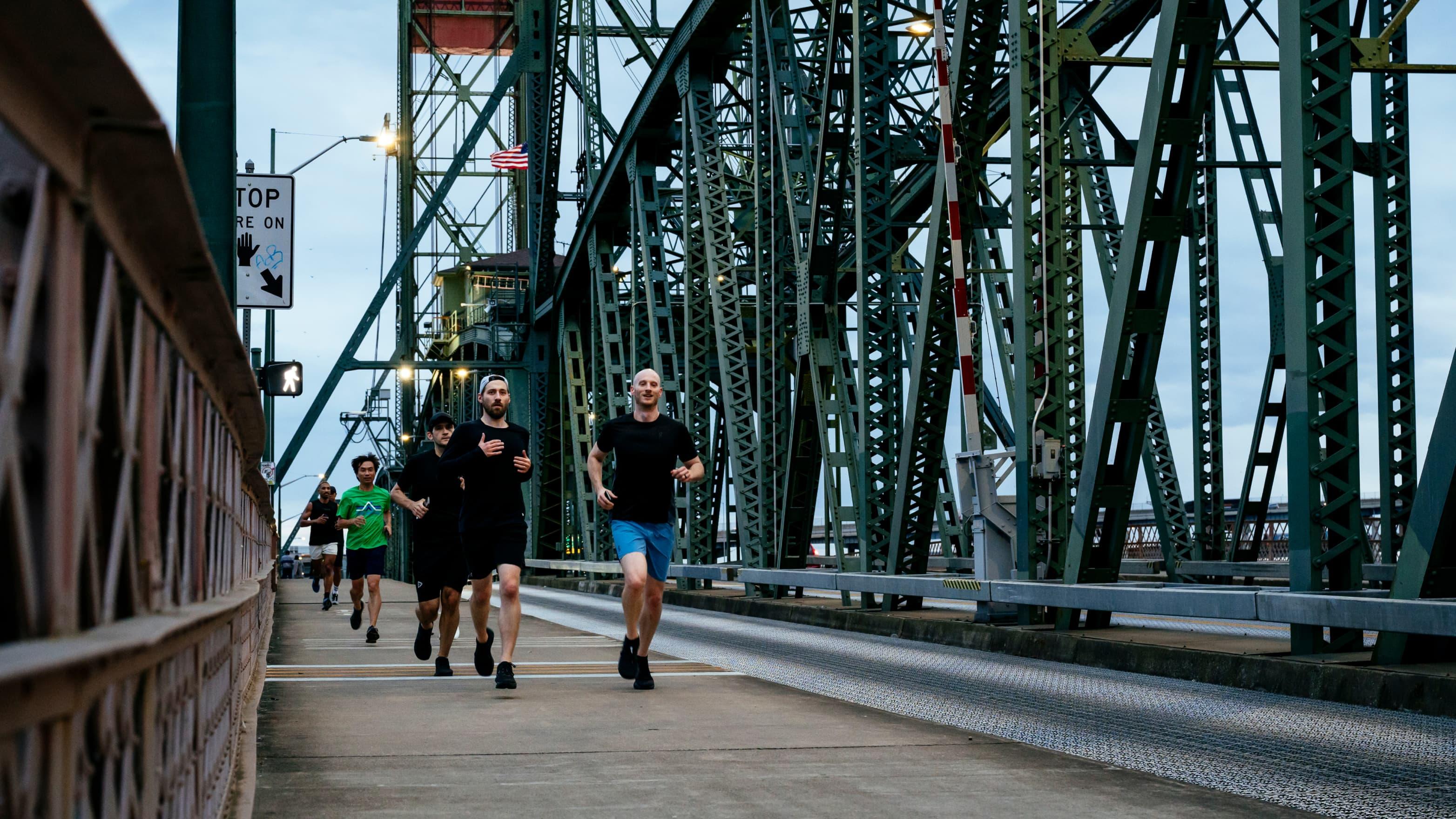 A group of runners runs across the Portland Bridge