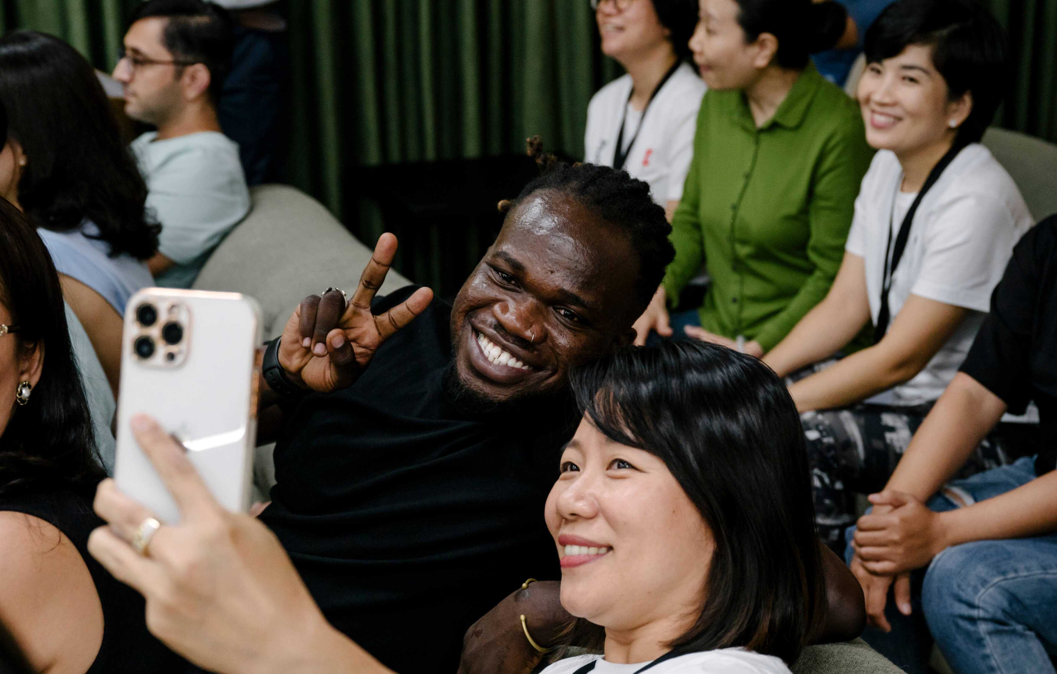 Two people taking a selfie together sat at a conference
