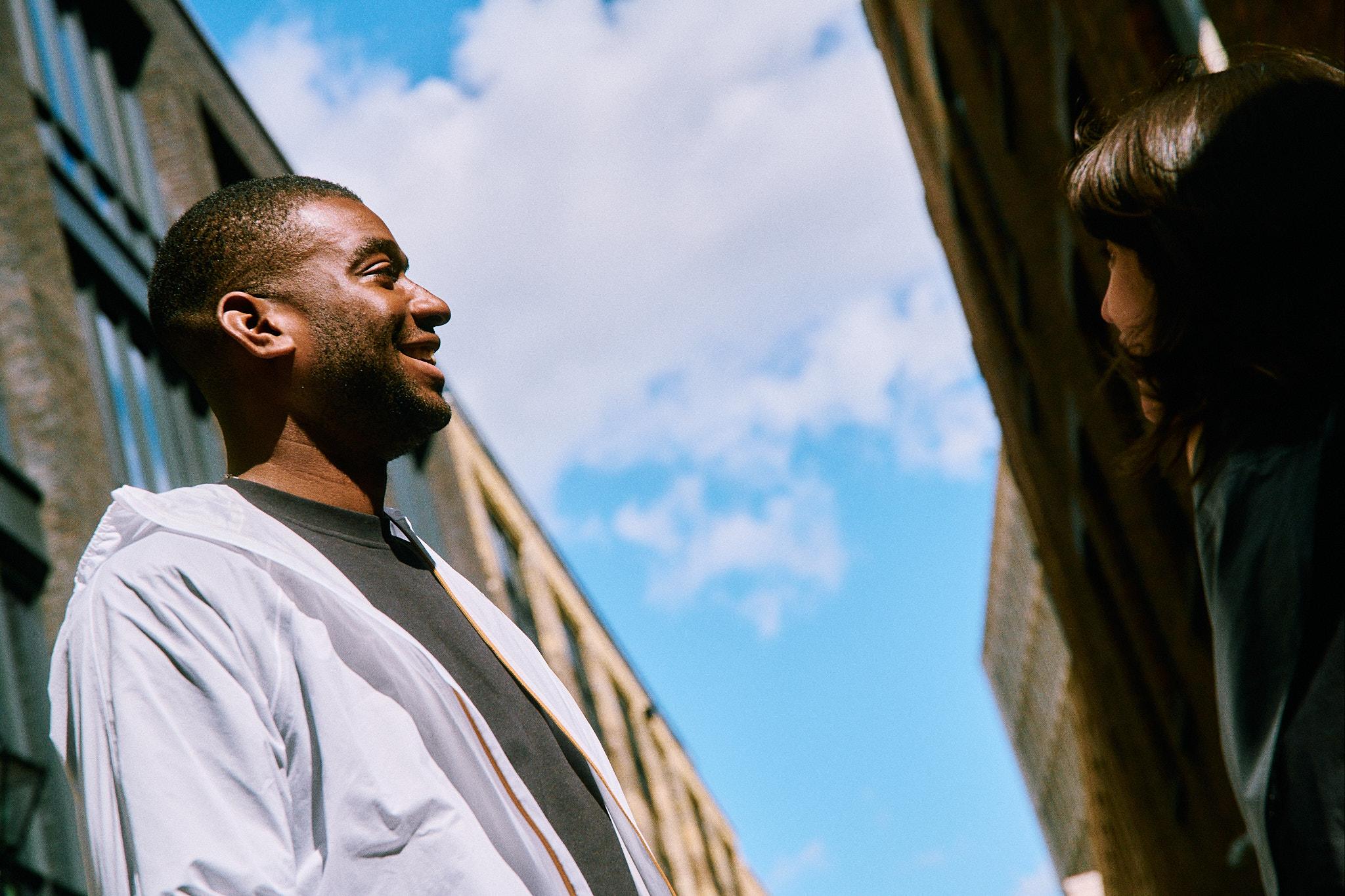 Two people laughing with a blue sky in the background