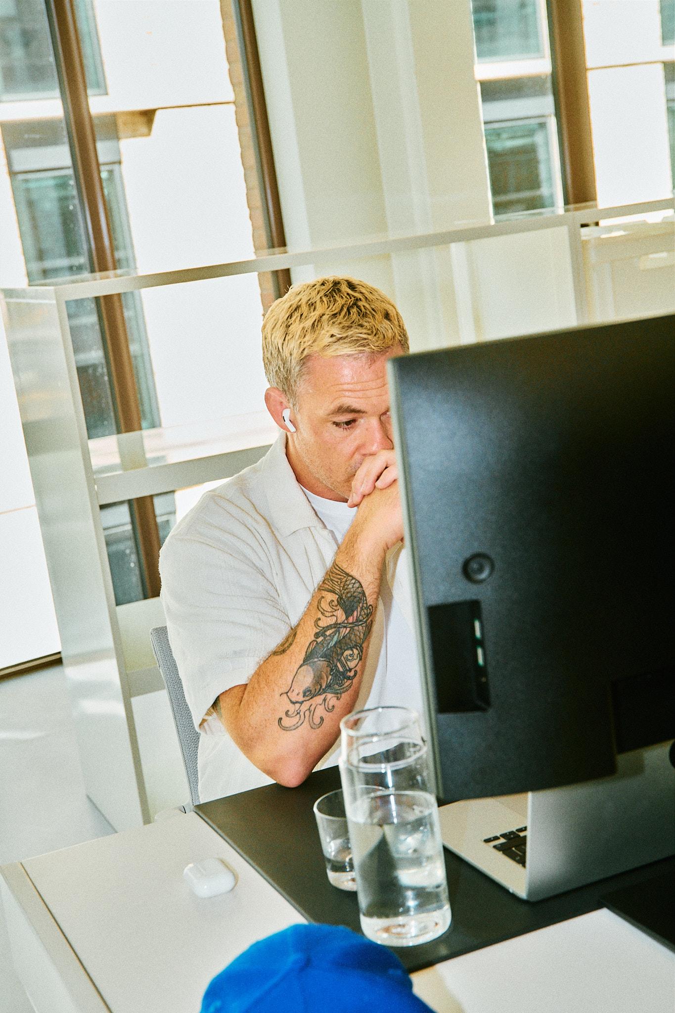 Man sitting on a desk and working on a laptop