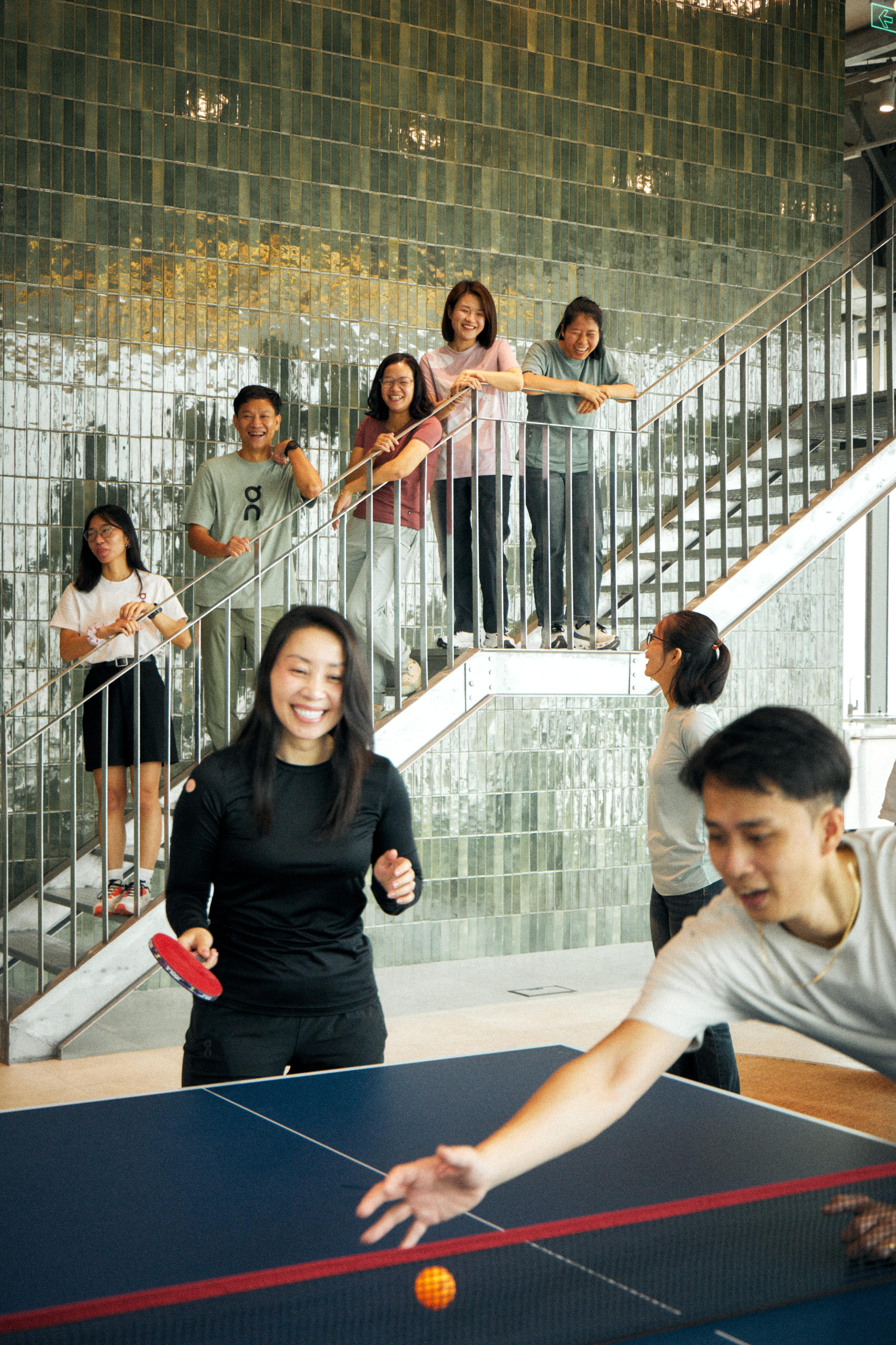 People on the stairs watching a ping pong match