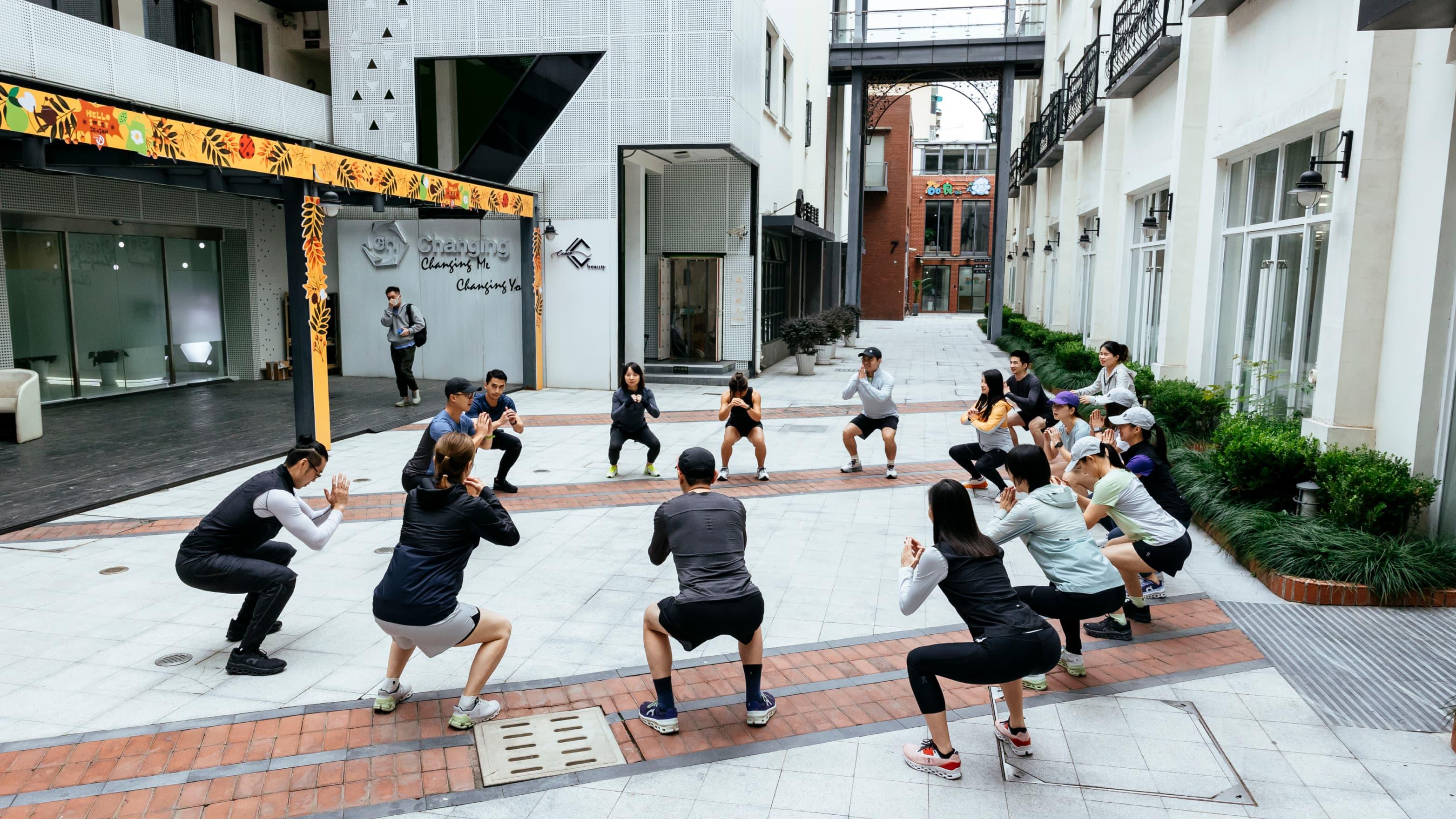 A group of people squats near the office building