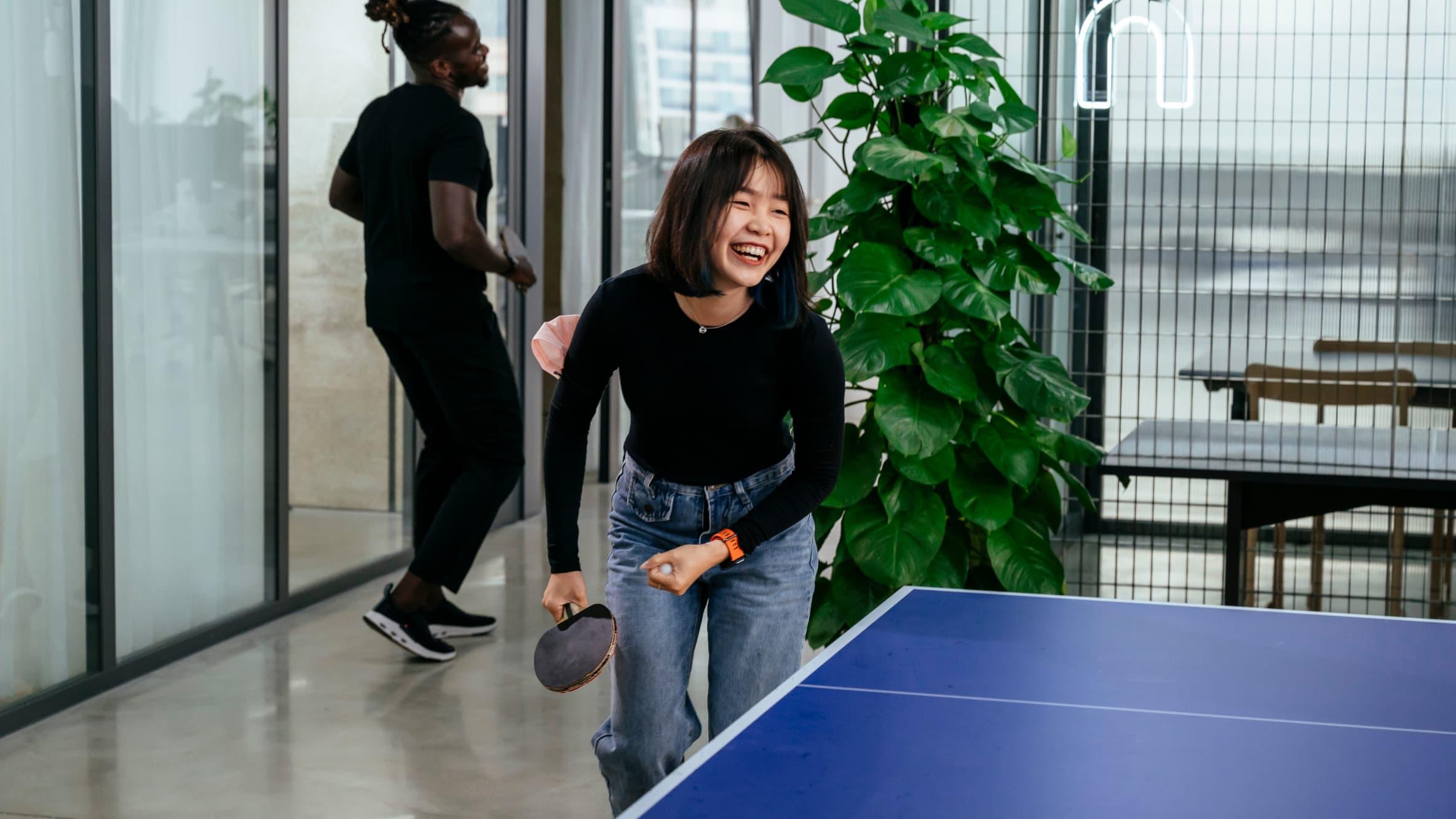 Woman laughing playing ping pong